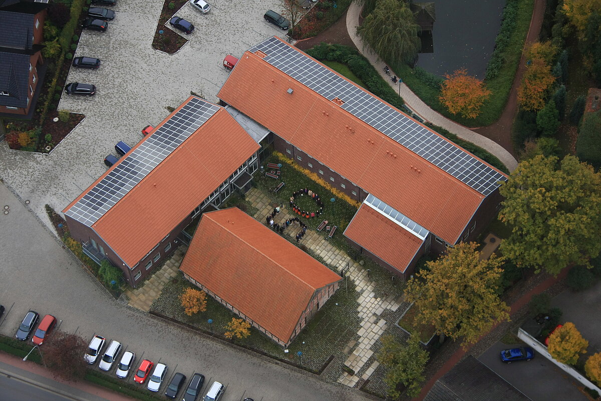 Luftaufnahme Ludgerus-Werk Das Ludgerus-Werk aus der Vogelperspektive. Man sieht Solaranlagen auf dem Dach. Im Innenhof stehen die Mitarbeiter zu einer 50 geformt.