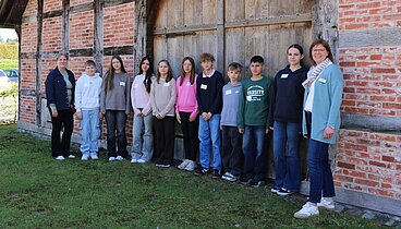 Die Gruppe Teilnehmer*innen am Zukunftstag stehen mit Betreuerin Britta von Lehmden vor der Hofstelle des Ludgerus-Werk. 