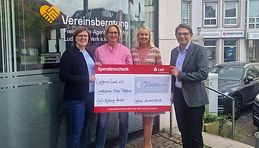 Vier Personen stehen vor dem Büro der Vereinsberatung in Lohne und halten einen symbolischen Check über 2000 Euro in den Händen. 