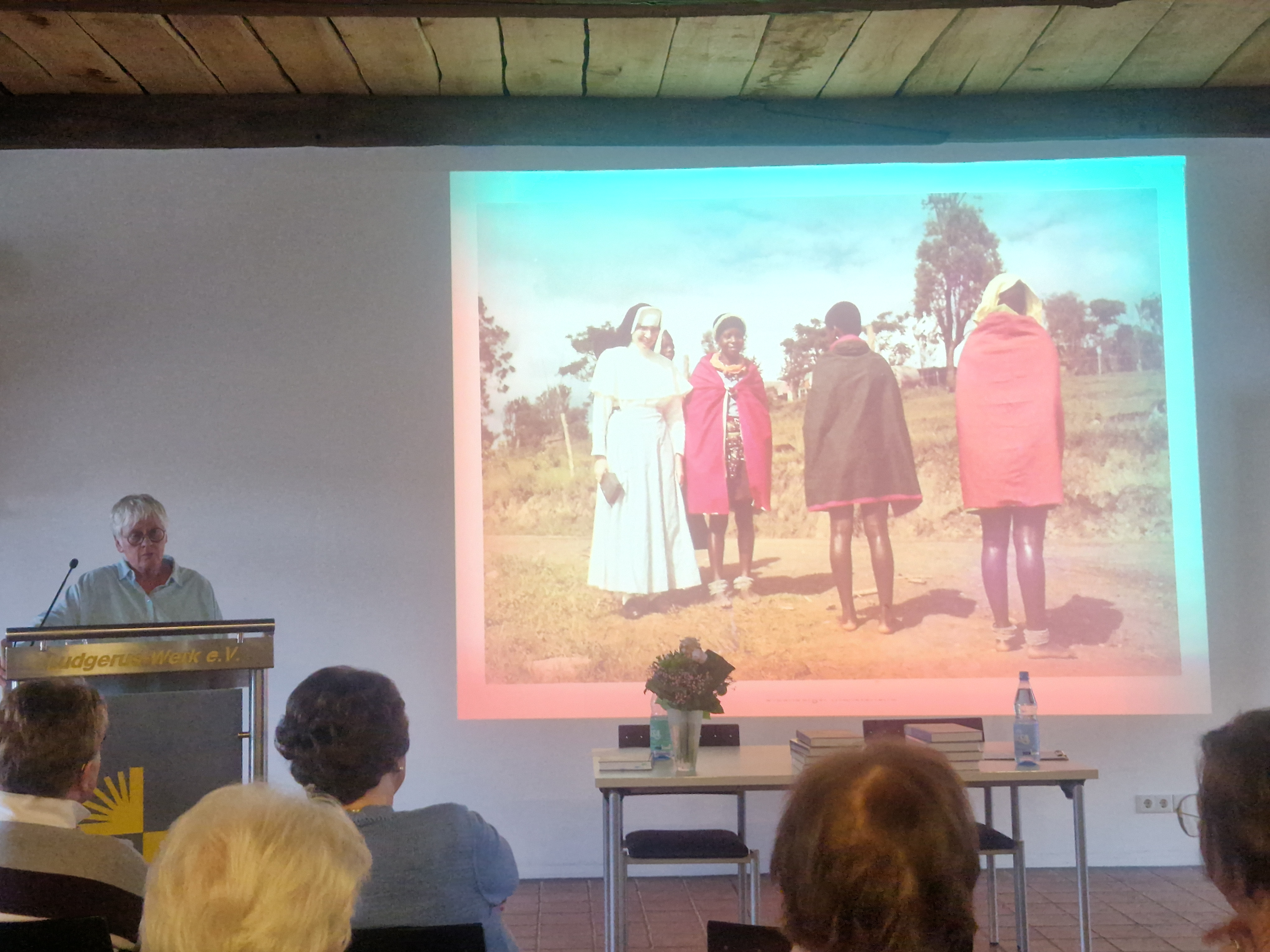 Die Dozentin Prof. Dr. Aka steht vor ihrer Präsentation über die Missionarinnen. Davor sitzen die Zuhörenden des Vortrags.
