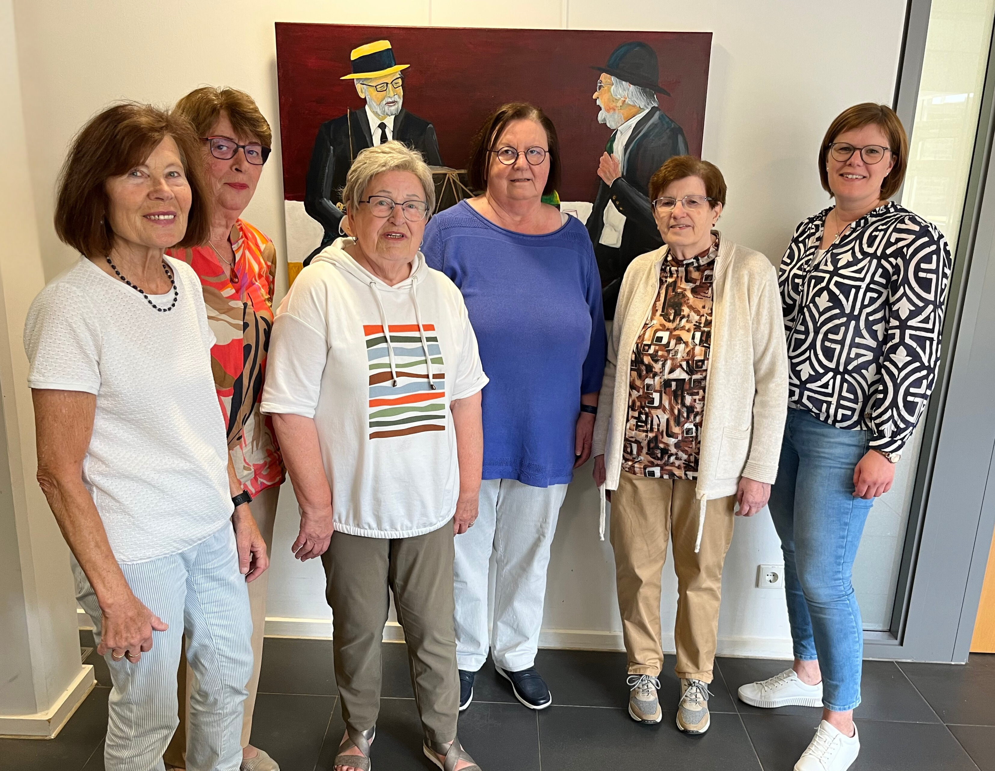 Die Gruppe der Montagsmalerfrauen stehen vor einem ihrer Kunstwerke.