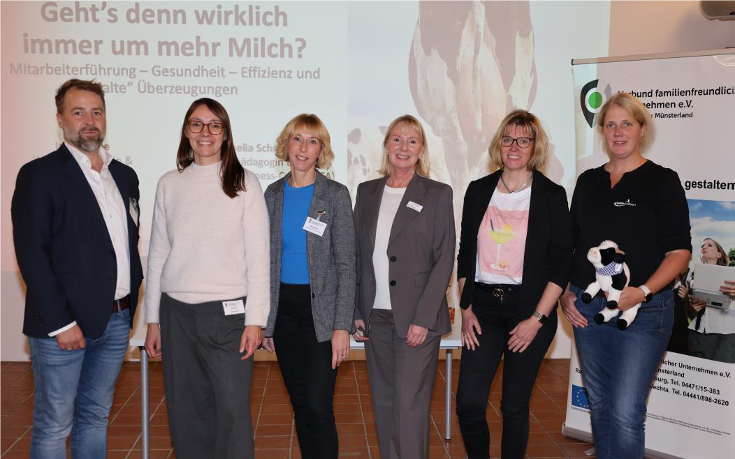 Eine Gruppe Leute in stehen vor der Leinwand in der Hofstelle im Ludgerus-Werk. Die Person, die ganz rechts steht, hält eine Stoffkuh in den Händen. 