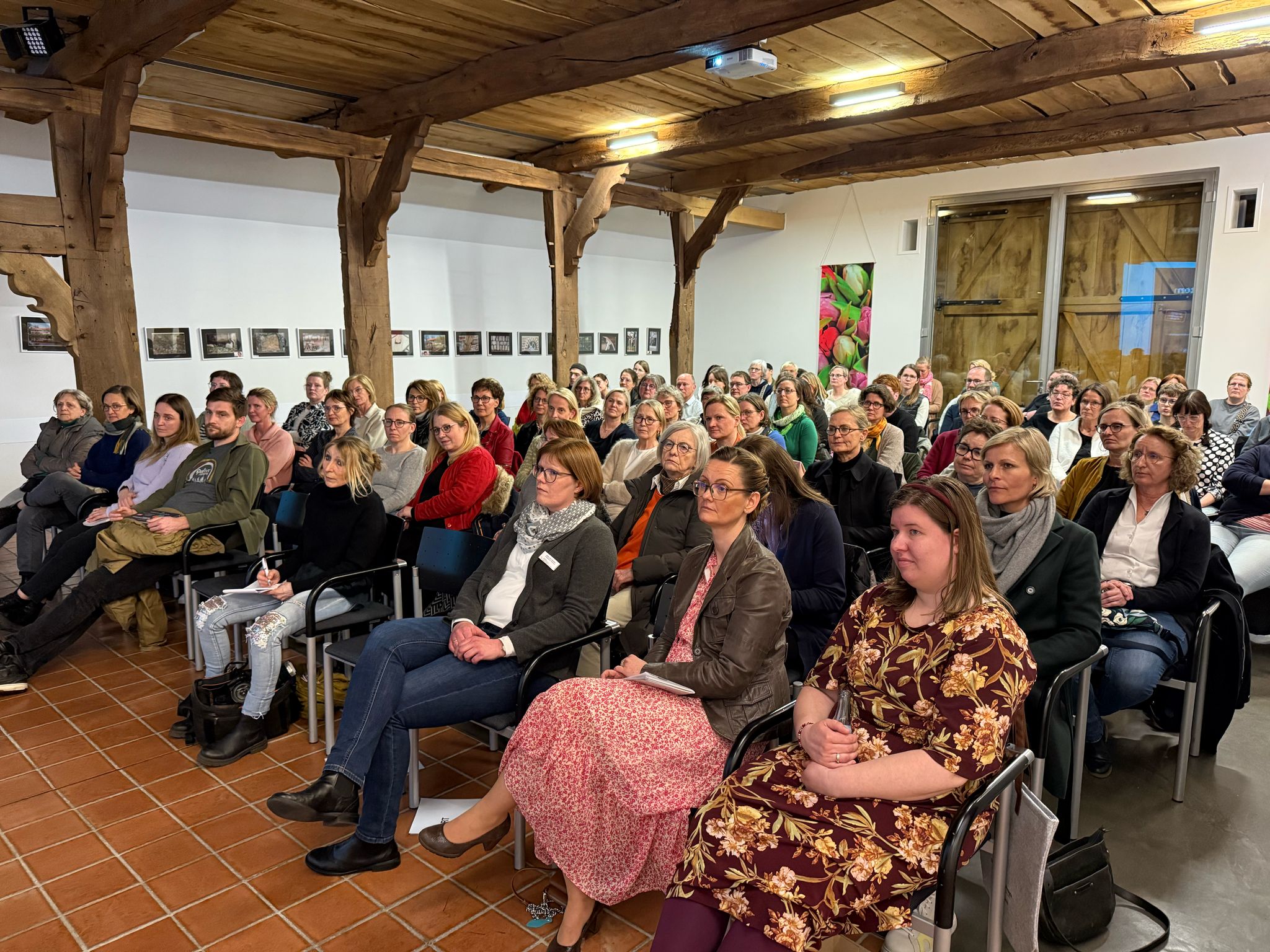 Die Hofstelle des Ludgerus-Werk. Das Publikum sitzt dicht beieinander und hört gespannt der Vortragenden zu.
