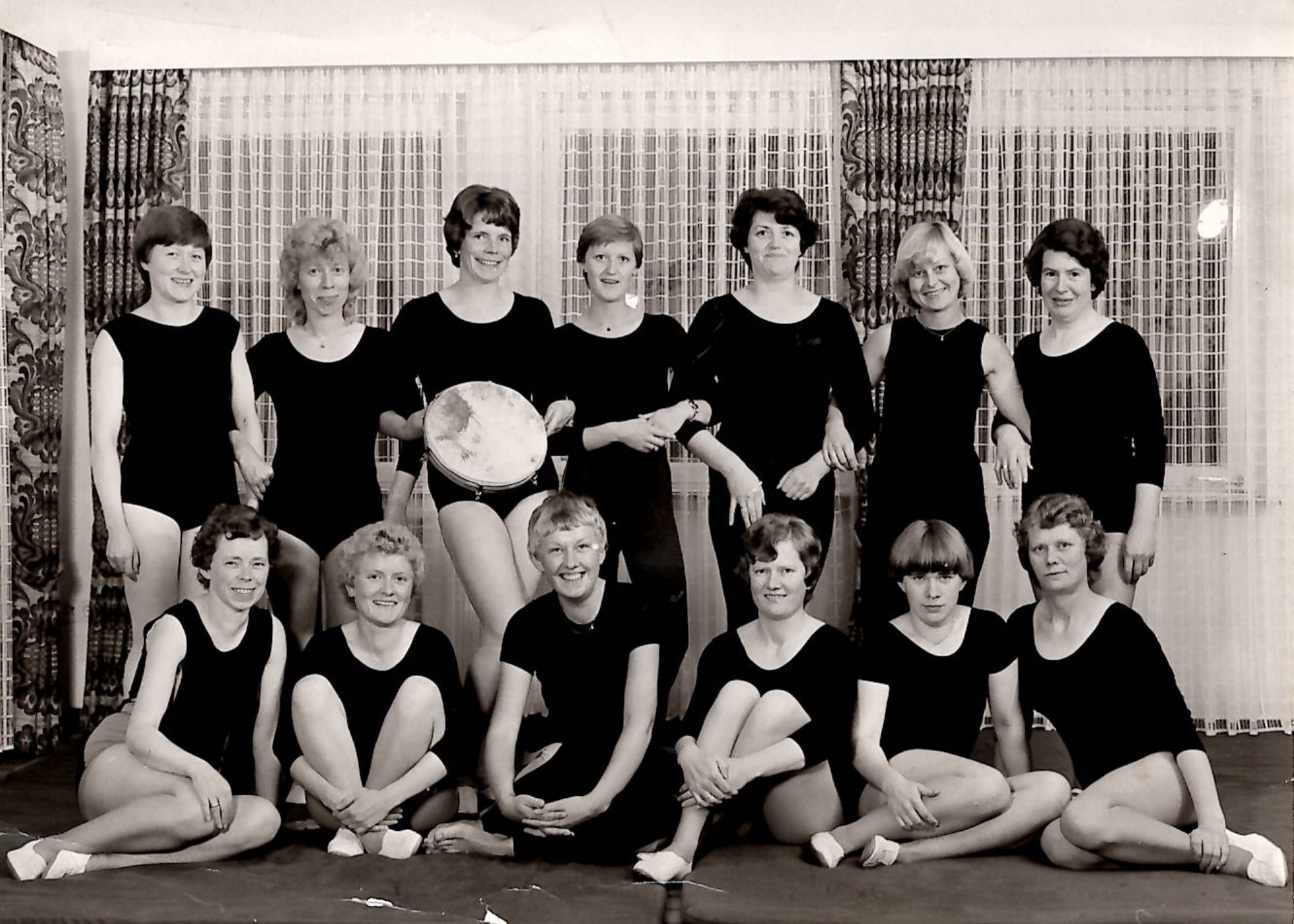 Ein schwarz-weiß Bild von einer Gruppe junger Frauen in Gymnastik-Anzügen.